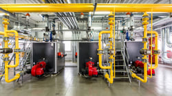 Industrial warehouse with yellow pipes connected to black machines